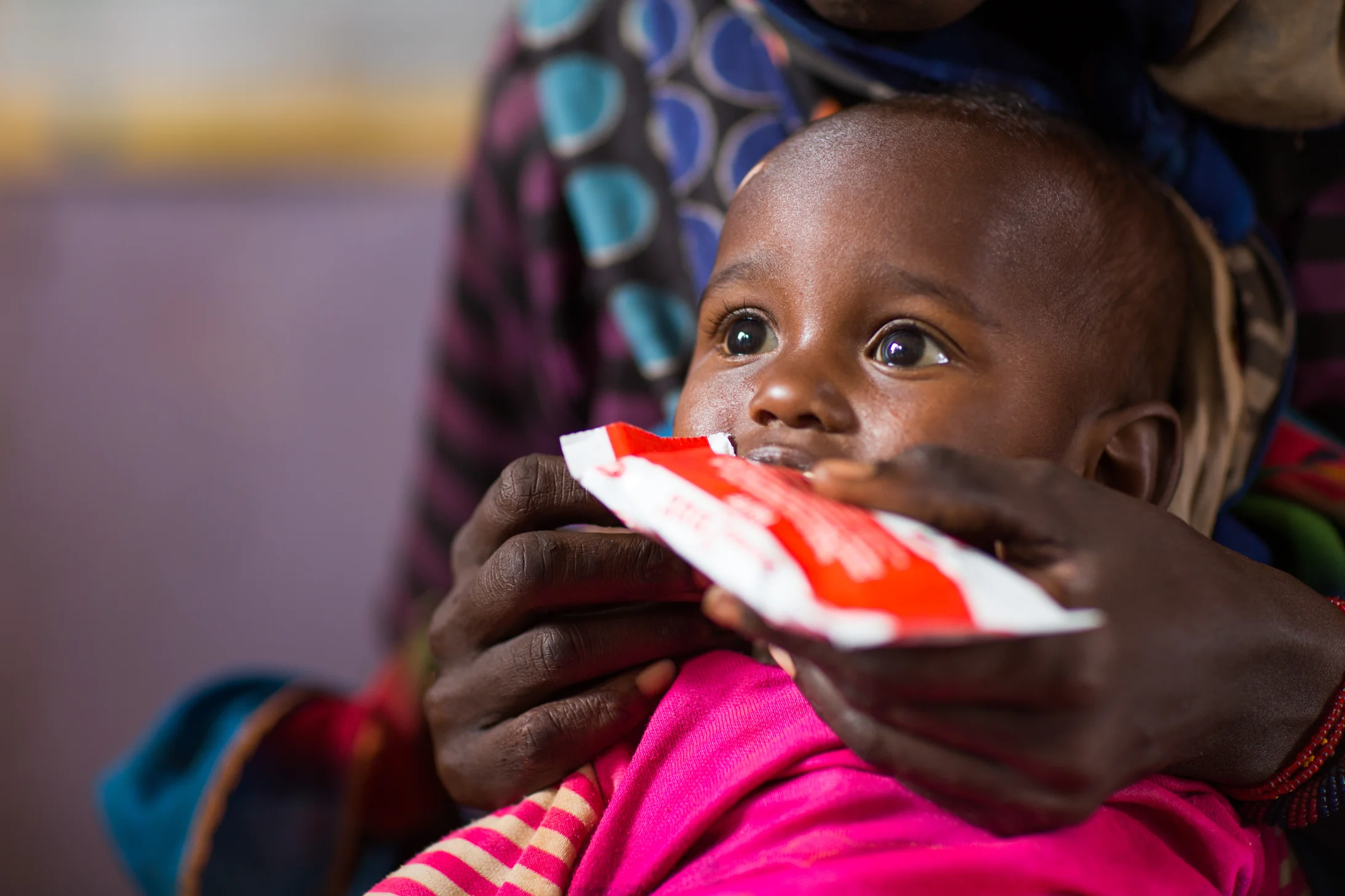 Un enfant de deux ans se nourrit de l'alimentation thérapeutique