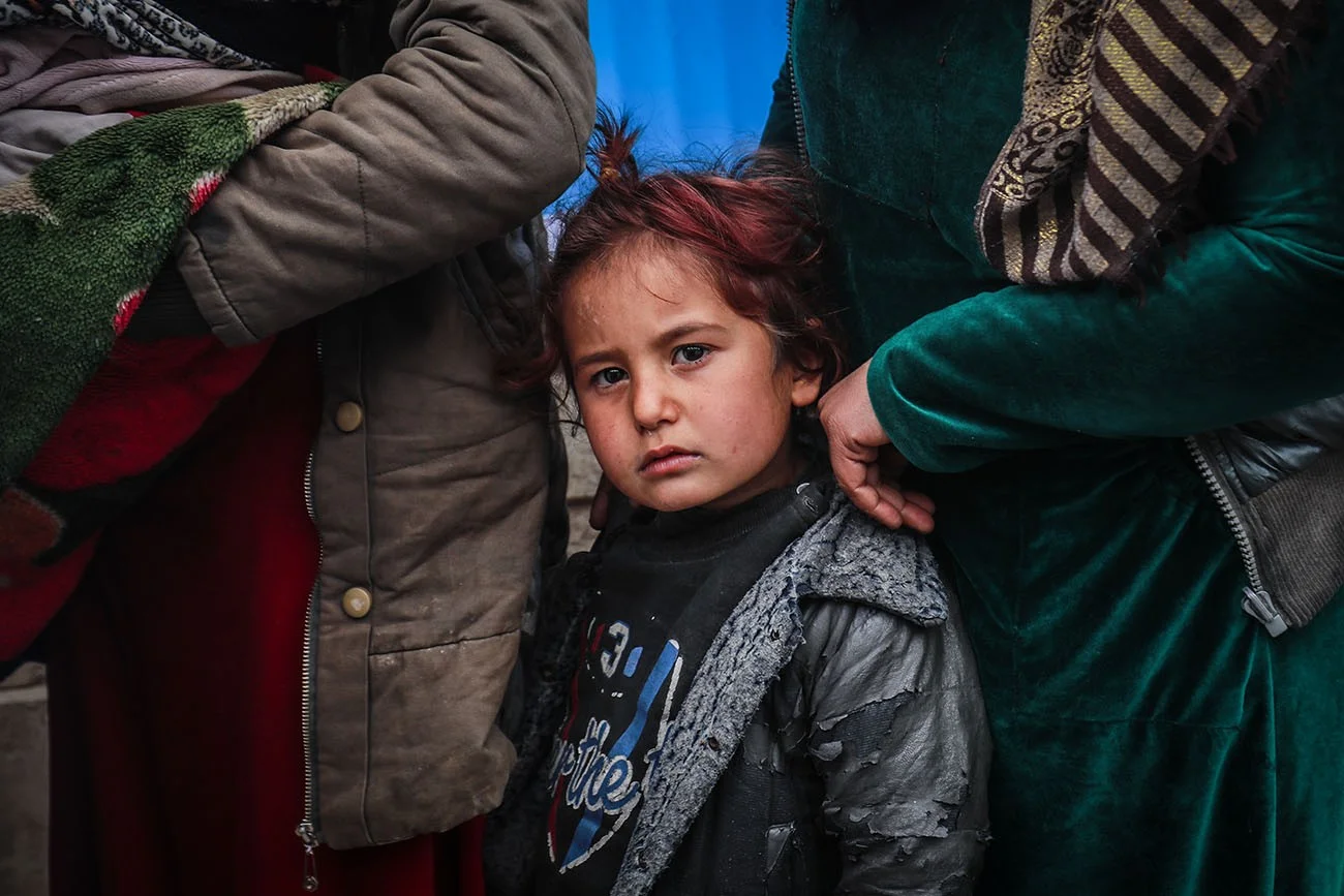 Ein Mädchen steht mit ihrer Familie vor einer mobilen UNICEF-Gesundheitsklinik in der Musab-Bin-Omir-Moschee in Hasaka, Syrien. © UNICEF/UN0583326/