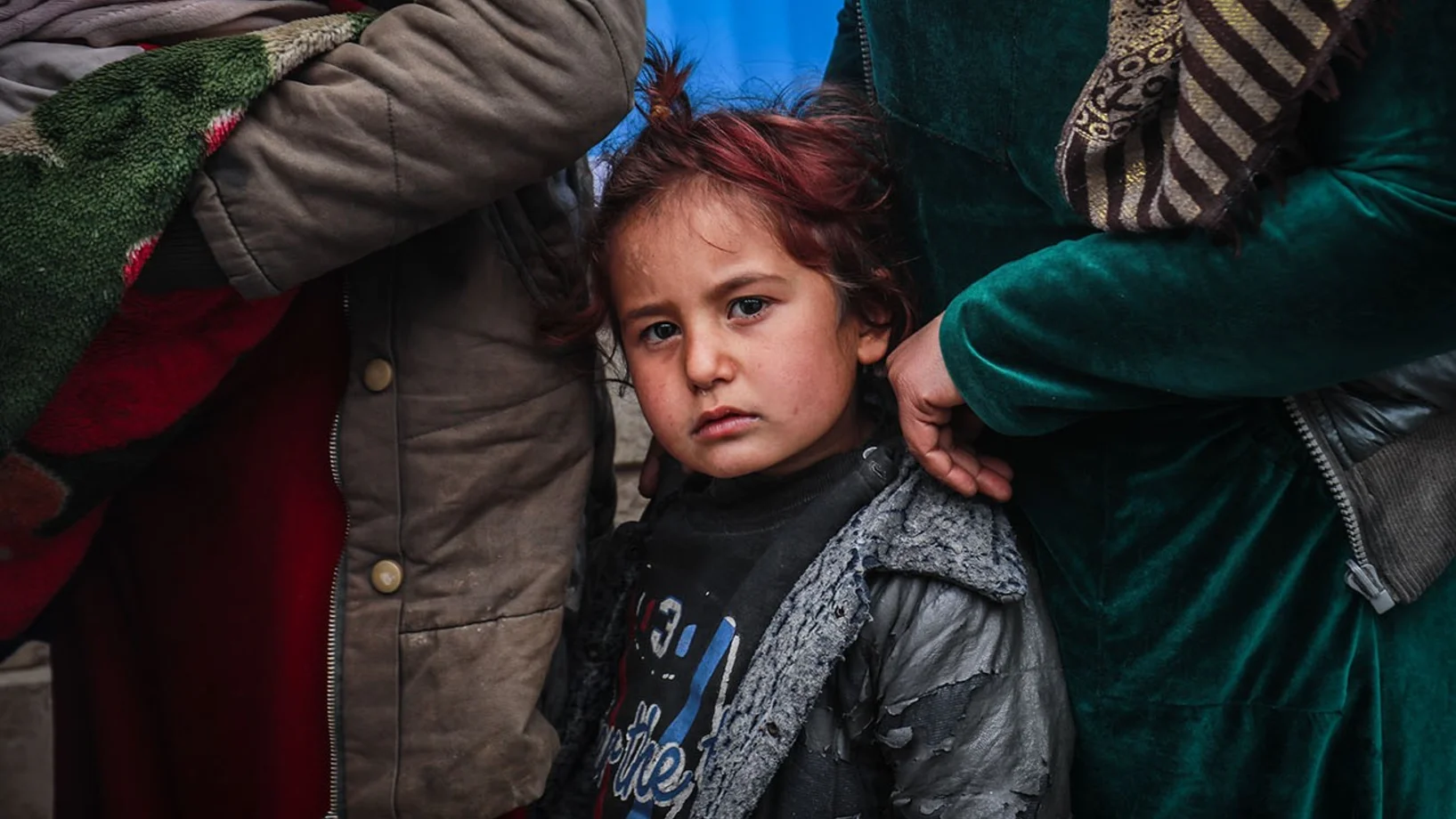 Ein Mädchen steht mit ihrer Familie vor einer mobilen UNICEF-Gesundheitsklinik in der Musab-Bin-Omir-Moschee in Hasaka, Syrien. © UNICEF/UN0583326/