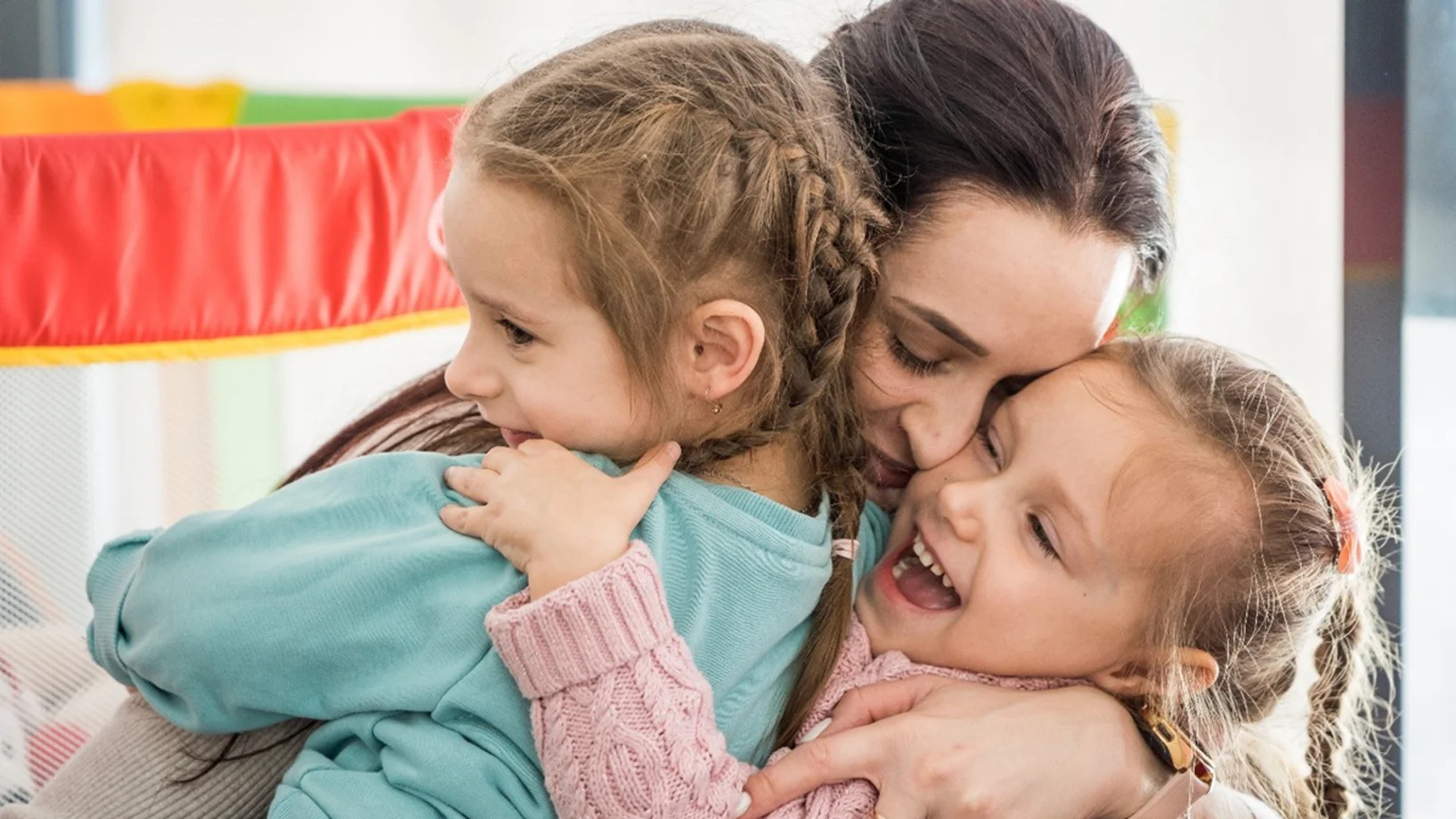 Mutter hält Kinder im Arm.