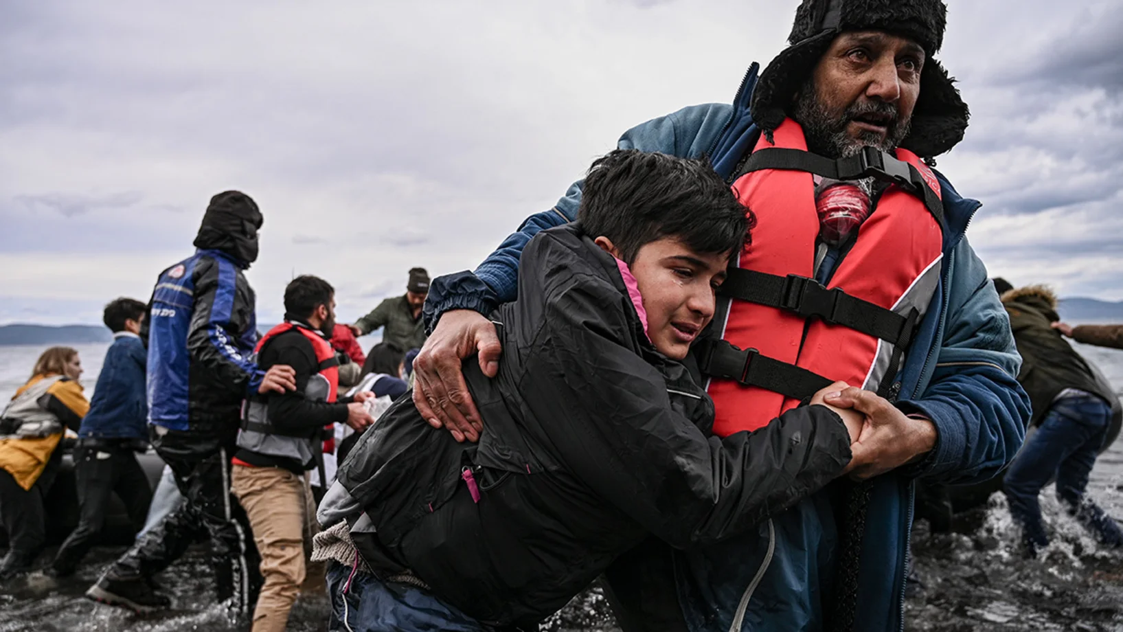 Un homme aide un enfant à marcher.