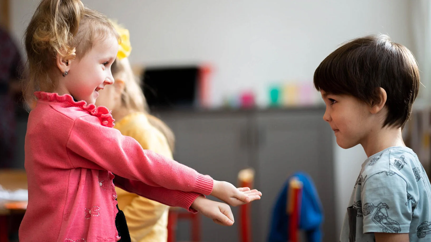 Kinder reichen sich die Hand.