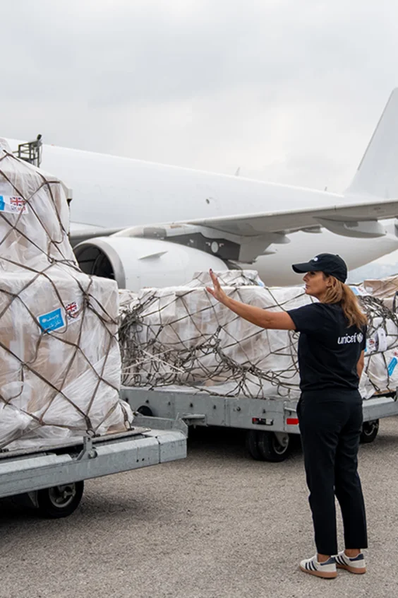 UNICEF Hilfslieferungen stehen vor einem Flugzeug.